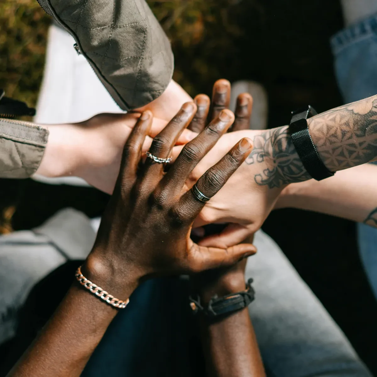Diverse group of people stacking hands together in a gesture of unity and teamwork