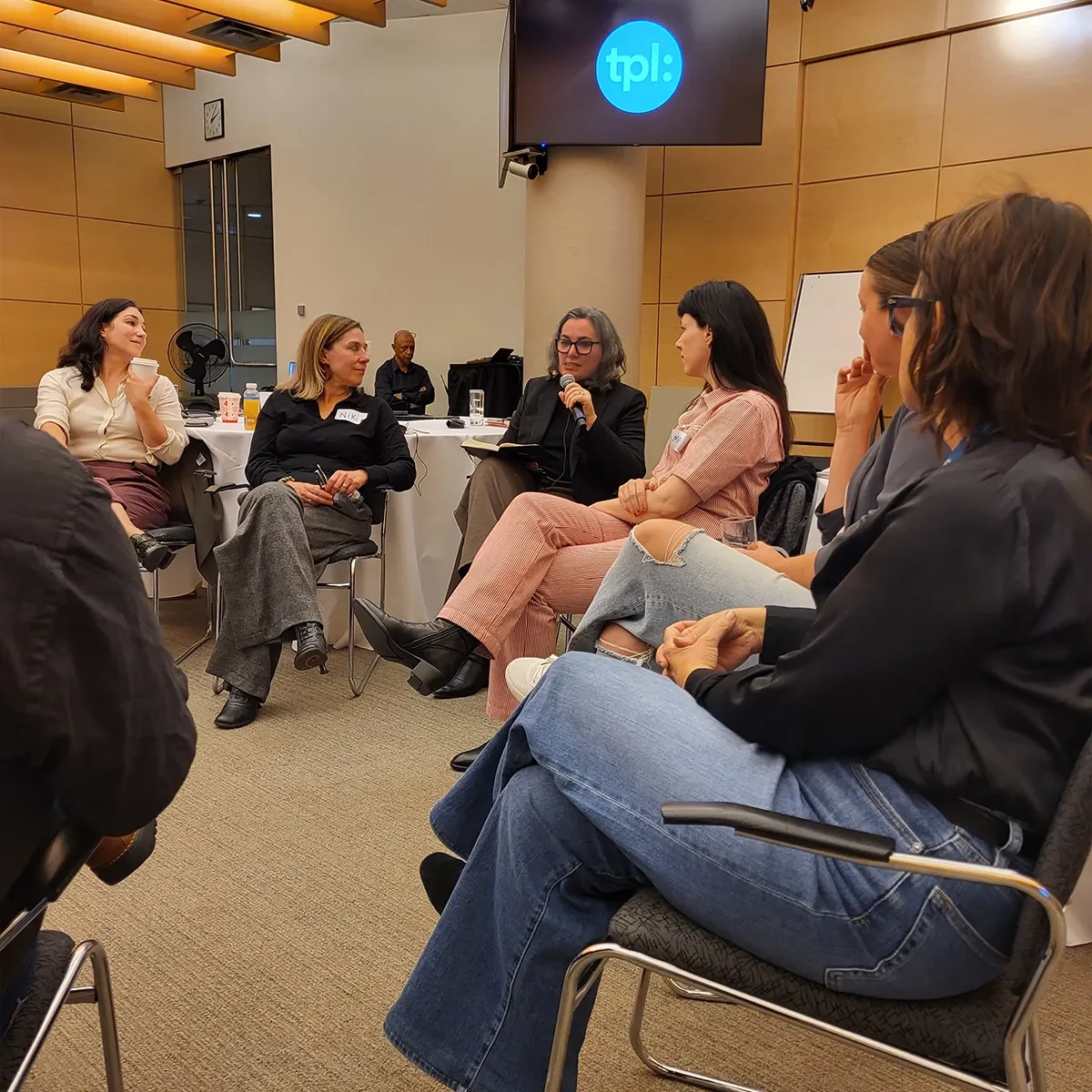 Group of people seated in a circle participating in a discussion in a meeting room