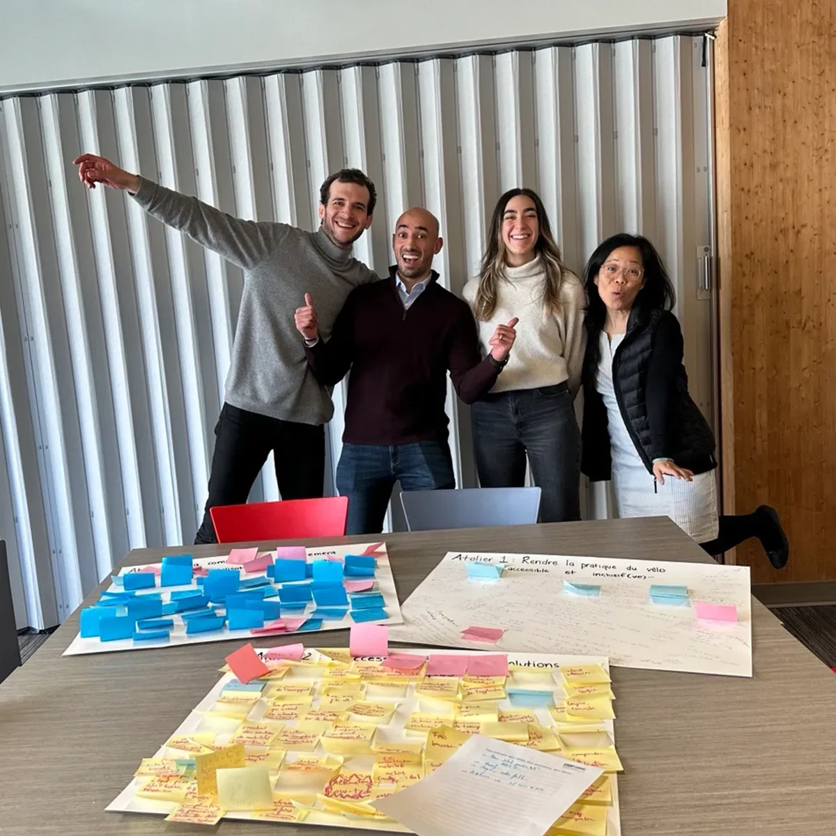 Group of people collaborating around a table covered in sticky notes during a workshop