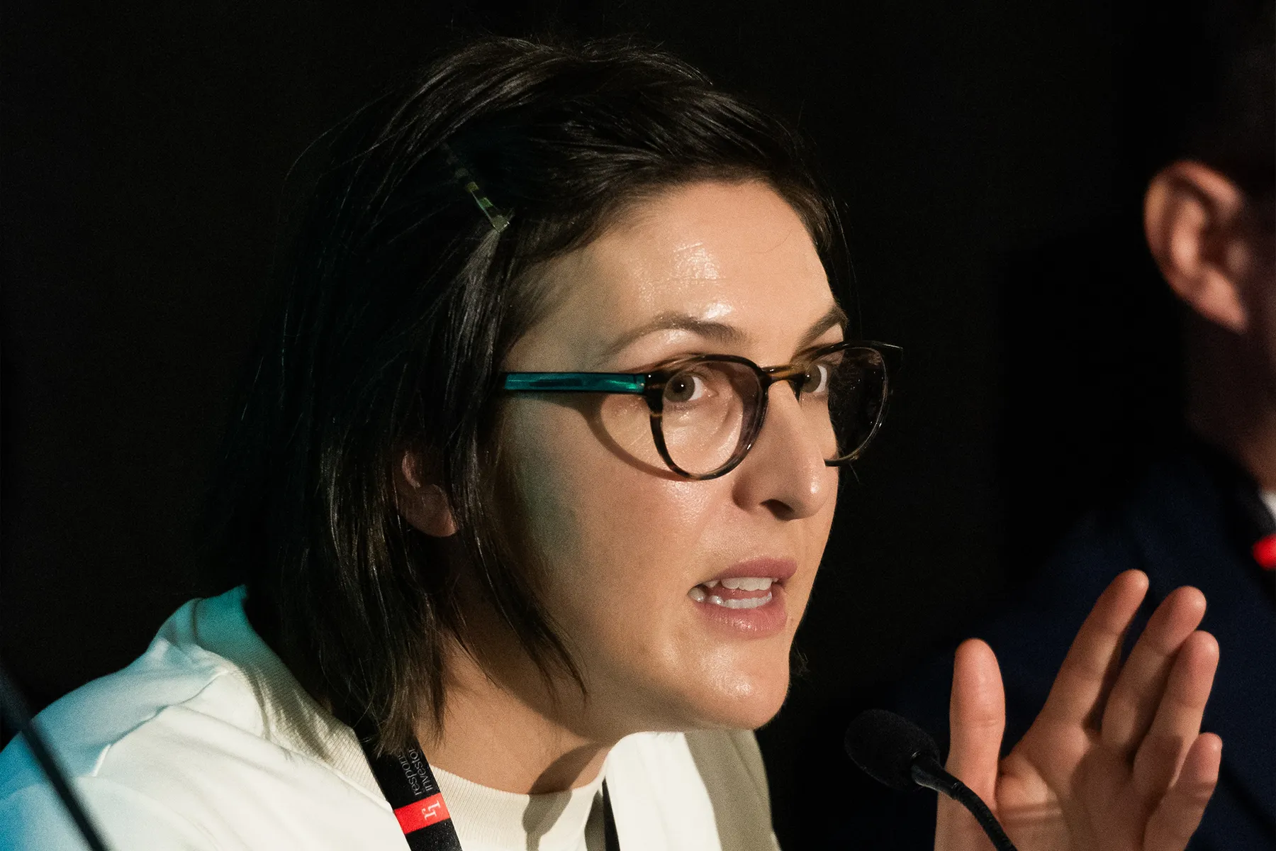 Close-up of a person wearing glasses speaking, with a focused expression